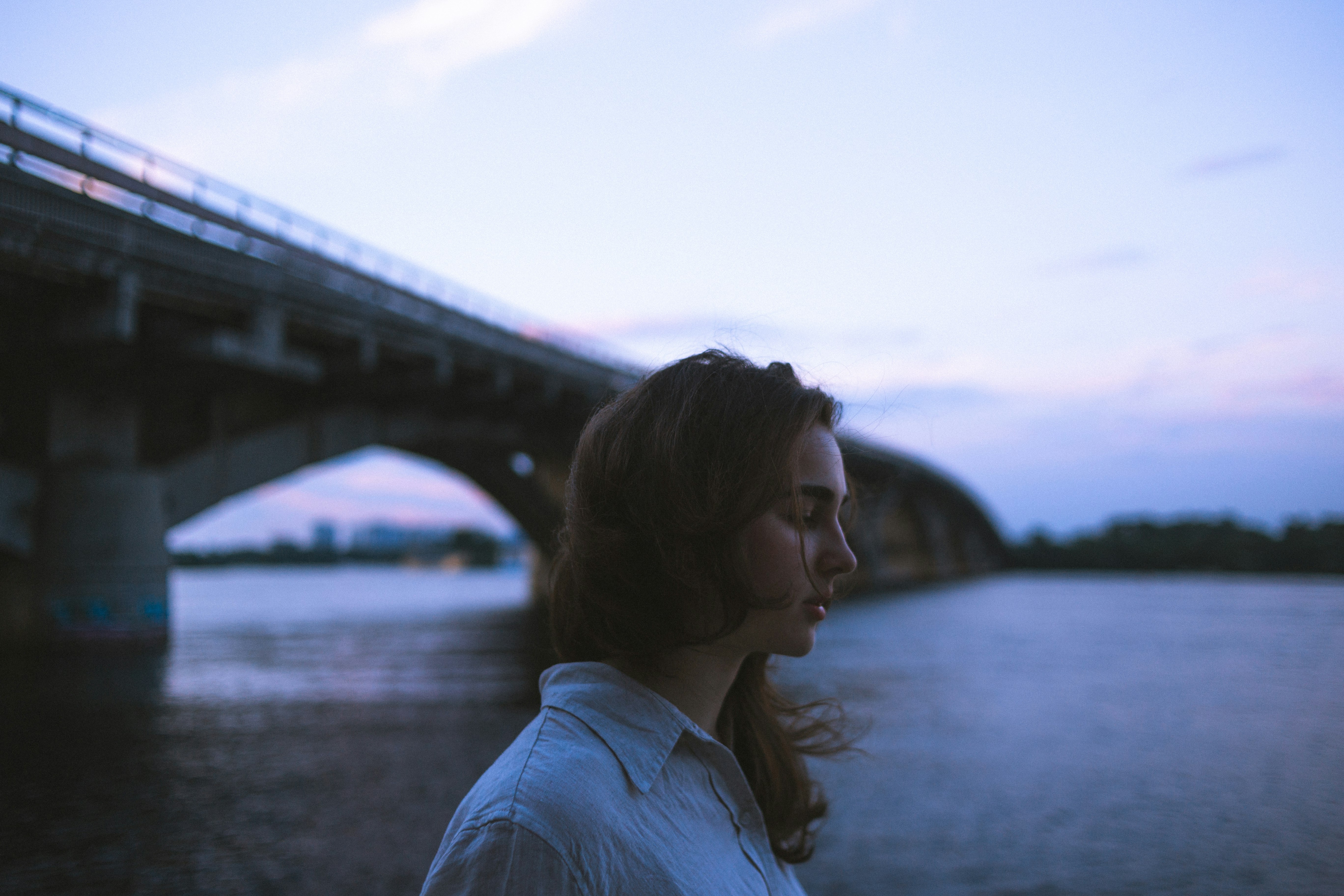 woman in white shirt standing near bridge during daytime